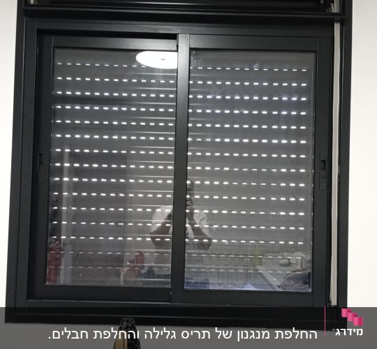 חלון עם תריסים סגורים ובגדים תלויים